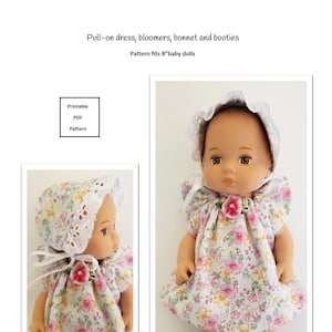 May include: A doll wearing a floral print pull-on dress, bonnet, bloomers, and booties. The outfit features pink, yellow, and white flowers on a light background. The bonnet and booties are trimmed with white lace. The text on the image says "Pull-on dress, bloomers, bonnet and booties".