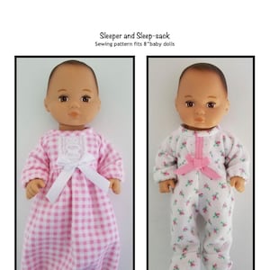 May include: Two 8-inch baby dolls wearing pink and white gingham and floral print sleepers. The sewing pattern for these sleepers is available for purchase. The text "Sleeper and Sleep-sack Sewing pattern fits 8"baby dolls" and "Kathy Anne Designs for dolls" is included in the image.