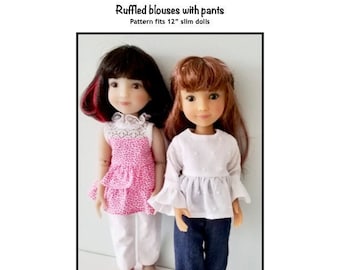 May include: Two 12-inch dolls wearing ruffled blouses and pants. The doll on the left is wearing a pink ruffled blouse with white pants and pink shoes. The doll on the right is wearing a white ruffled blouse with blue jeans and pink shoes. The text "Ruffled blouses with pants" and "Pattern fits 12" slim dolls" is above the dolls. The text "Kathy Anne Designs for dolls" is below the dolls.