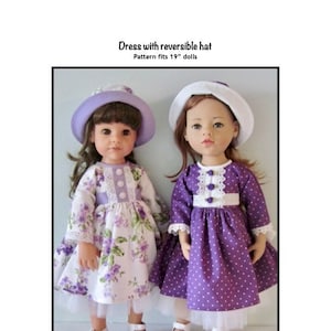 Pode incluir: Duas bonecas vestindo vestidos e chapéus roxos. Uma boneca está usando um chapéu branco com bolinhas roxas e um vestido roxo com bolinhas brancas. A outra boneca está usando um chapéu lavanda e um vestido com estampa floral. Ambas as bonecas estão usando sapatos brancos e têm cabelos longos e castanhos. O texto "Dress with reversible hat" e "Pattern fits 19" dolls" é visível no topo da imagem. O texto "Kathy Anne Designs for dolls" é visível na parte inferior da imagem.