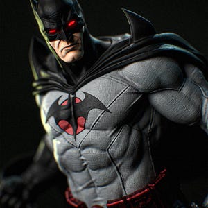 Puede incluir: Figura detallada de Batman con un traje gris y negro con un símbolo de murciélago en el pecho. La figura tiene una expresión severa, ojos rojos brillantes y una capa negra. El cinturón es rojo.