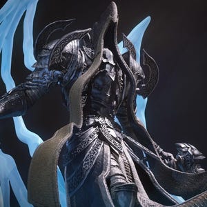 May include: A dark, armored figurine featuring a hooded, faceless figure in intricate metallic plating. The figure holds two curved blades, with translucent, glowing light blue energy tendrils extending from the back like wings.