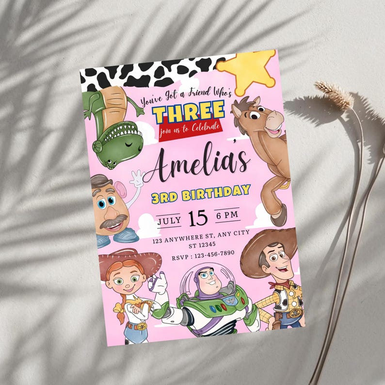 Puede incluir: Una tarjeta de invitaci&oacute;n de cumplea&ntilde;os rosa con personajes de dibujos animados que incluyen un dinosaurio verde, un caballo marr&oacute;n, una figura de patata, una vaquera, un guardi&aacute;n espacial y un vaquero. El texto dice You've Got a Friend Who's THREE, Amelia's 3RD BIRTHDAY, July 15 6 PM.