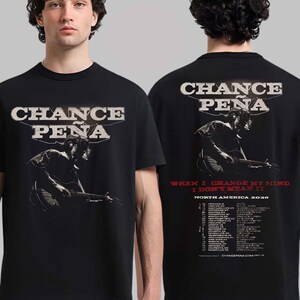 May include: Black t-shirt with the text "CHANCE PENA" in a vintage style font. The front of the shirt shows an image of a person playing a guitar. The back of the shirt includes tour dates and the text "WHEN I CHANGE MY MIND I DON'T MEAN IT".