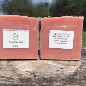 May include: Two square bars of pink Rose Clay Soap, each with a label. The labels include the brand name, product name, and weight of 4.5 oz. Ingredients include olive oil and pink kaolin clay.