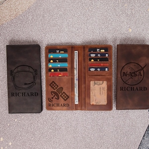 May include: Three brown leather wallets. One closed wallet features an astronaut helmet design and the name "RICHARD". An open wallet displays credit cards and a bill. The third wallet has the NASA logo and the name "RICHARD".