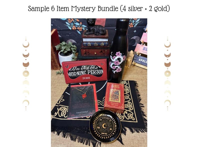Op de afbeelding: Een verzameling mystieke items, waaronder een zwarte waterfles met een bloemen slangenontwerp, een rode oogmaskerdoos met de tekst "I'm Not A Morning Person" en een tarotkaartspel. Een zwart Ouija-bord en een ketting zijn ook inbegrepen.
