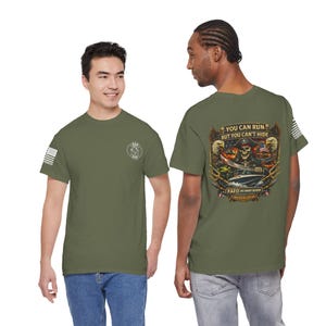 May include: Olive green t-shirts with a graphic on the back featuring a skull wearing a pirate hat, the American flag, and the text "YOU CAN RUN BUT YOU CAN'T HIDE". The front has a small logo and an American flag.
