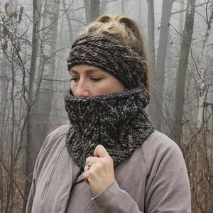 May include: A brown and black knit headband and neck warmer set. The headband is worn on the head and the neck warmer is worn around the neck. The set is made of a soft, warm yarn.