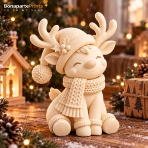 May include: A cream-colored 3D printed figurine of a reindeer wearing a knit-textured hat with a pom-pom, a matching knit scarf, and leg warmers. The reindeer has large antlers, a smiling expression, and holly berry details on the hat.