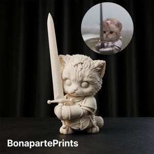 May include: A cream-coloured figurine of a kitten dressed in knight armour, holding a long sword upright with both paws. The kitten has large, round eyes and textured fur details. A circular inset shows a realistic kitten in similar armour.