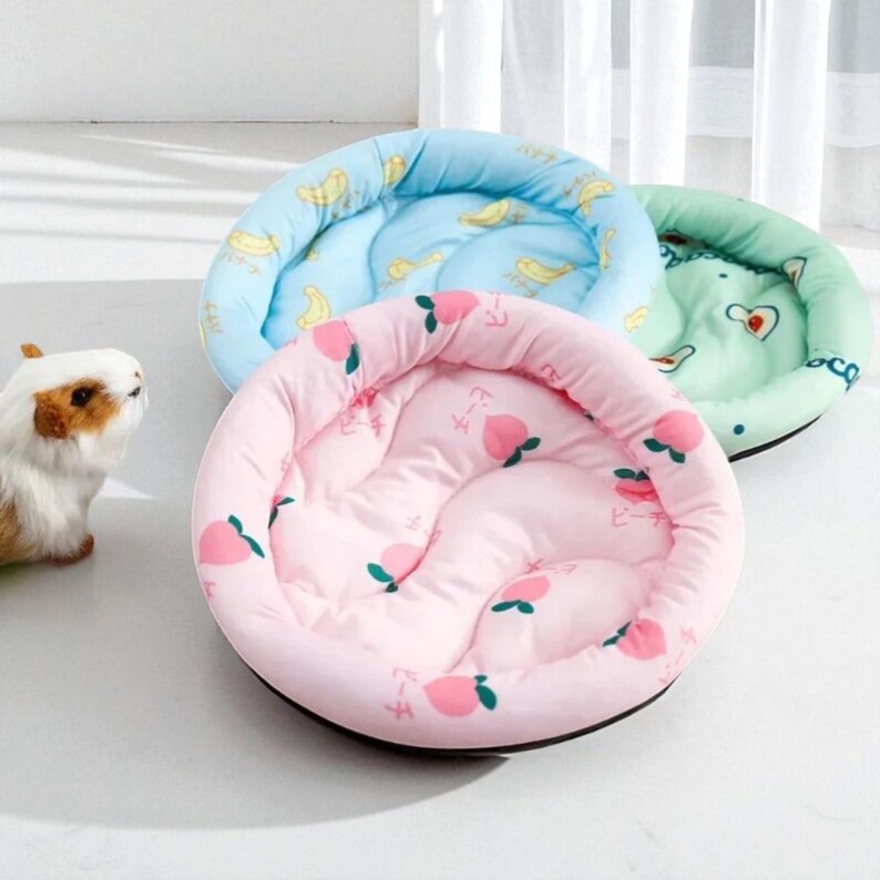 Puede incluir: Tres camas redondas para mascotas en colores pastel. La cama rosa tiene un estampado de melocotones, la cama azul tiene un estampado de pl&aacute;tanos y la cama verde tiene un estampado de corazones. Las camas son de material acolchado suave.