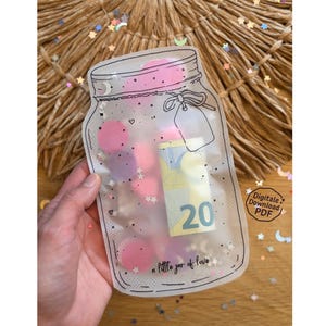 May include: A clear jar-shaped pouch with a black outline, filled with pink confetti, stars, and a 20 Euro bill. The text "a little jar of love" is at the bottom. The pouch is held by a hand.