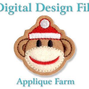 Op de afbeelding: Geborduurde applique-ontwerp van een bruine aap die een rode en witte kerstmanmuts draagt. De aap heeft een wit gezicht met een rode glimlach.