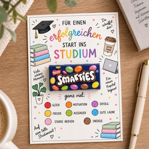 Könnte beinhalten: Eine rechteckige Grußkarte mit einer mittig platzierten Smarties-Schachtel und dem deutschen Text "FÜR EINEN erfolgreichen START INS STUDIUM". Die Karte ist mit Illustrationen von Doktorhut, Büchern, Kaffeetasse und Laptop sowie farbigen Kreisen mit Motivationsbegriffen verziert.