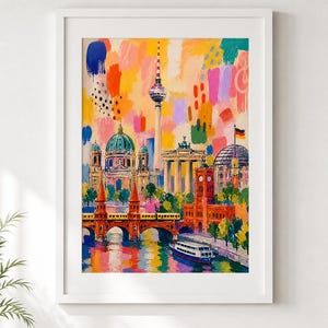 May include: Framed artwork showing Berlin landmarks, such as the Brandenburg Gate and Berliner Dom, with a vibrant, colourful style. The painting uses bold brushstrokes in orange, yellow, blue, and pink, with a bridge and a boat on the water.