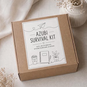 May include: A square brown cardboard box featuring a white label with black line art illustrations of a paper airplane, a coffee cup, a notebook, a pen, and a potted plant. The text reads AZUBI SURVIVAL KIT and ALLES, WAS DU BRAUCHST, UM DEINE AUSBILDUNG ZU ROCKEN.