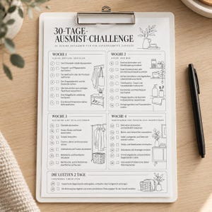 May include: A white clipboard holding a 30-day decluttering challenge checklist printed in German. The document features four weekly sections with numbered tasks, checkboxes, and line art illustrations of household items, accompanied by a black pen.