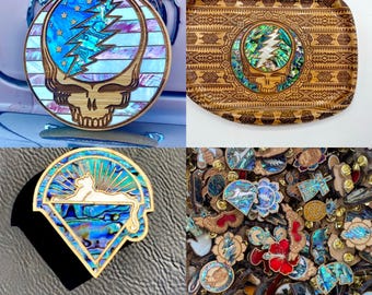Puede incluir: Una colección de cuatro diseños de incrustaciones de madera con un motivo de calavera y rayo inspirado en Grateful Dead. Los diseños están hechos con concha de abulón y madera y están disponibles en varios tamaños y formas.
