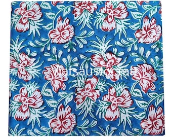 May include: A square of fabric with a repeating floral pattern. The design features large red and white flowers with green leaves and stems against a bright blue background. The fabric has a hand-blocked print appearance.
