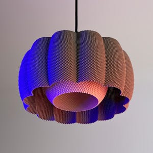 Könnte beinhalten: Eine moderne, strukturierte Pendelleuchte. Die Leuchte hat ein braunes und pfirsichfarbenes Farbschema mit blauer Akzentbeleuchtung. Die Leuchte ist an einem schwarzen Kabel aufgehängt und hat ein einzigartiges, geschichtetes Design. Geeignet für die Inneneinrichtung.