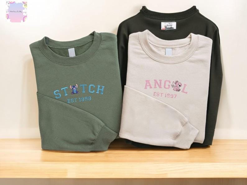 a pair of sweatshirts with the same design, laid out on a wooden surface.