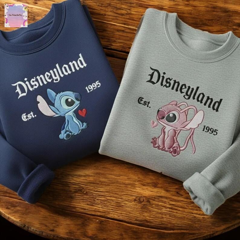 two sweatshirts with Disneyland branding, including a blue shirt and a gray shirt, both with the text "Disneyland Est. 1995" and the Disney character Lilo and Stitch.