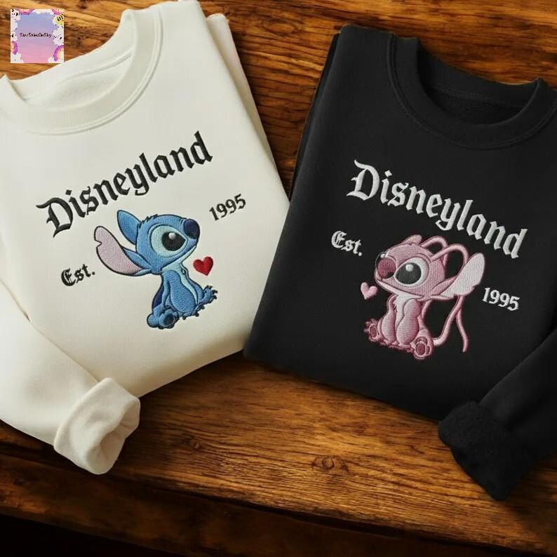 two Disney-themed sweatshirts, one white and one black, with the text "Disneyland" and "Est. 1995" printed on them.