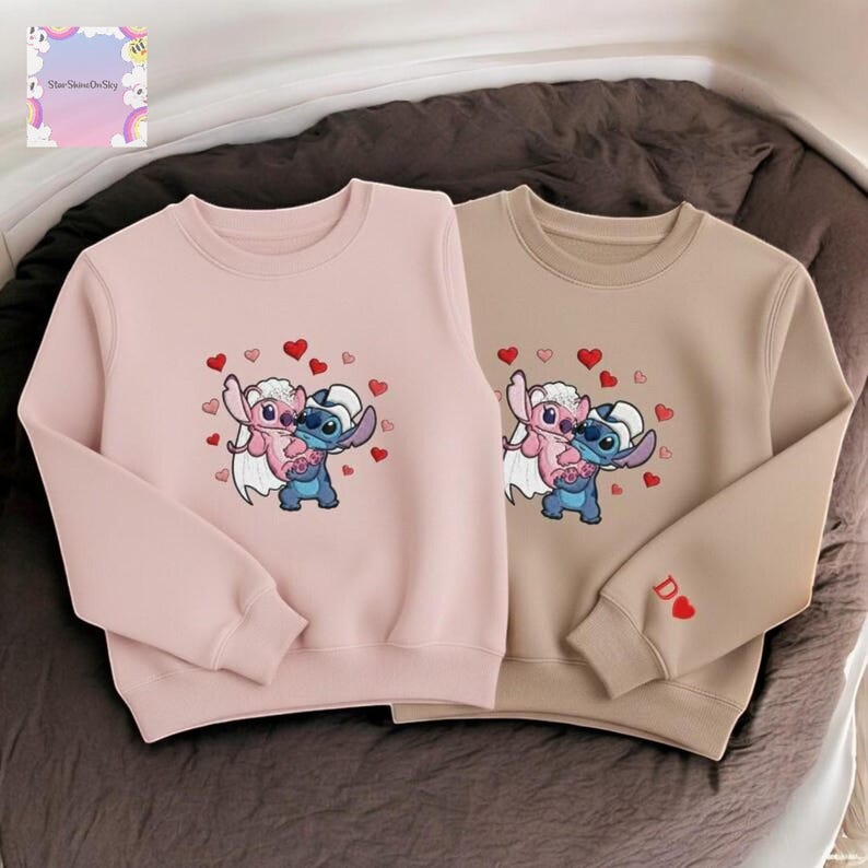 two sweatshirts with a cartoon character design, featuring a pink and blue character with hearts around it.
