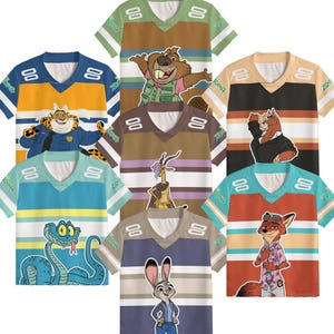 K&ouml;nnte beinhalten: Eine Auswahl an farbenfrohen Zootopia-T-Shirts. Jedes Shirt zeigt einen anderen Charakter, darunter ein Gepard, ein Biber, eine Schlange, ein Fuchs und ein Kaninchen. Die Shirts haben einen V-Ausschnitt mit Streifen und das Wort "Zootopia" auf den &Auml;rmeln.