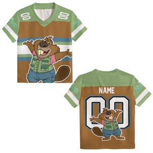 K&ouml;nnte beinhalten: Ein gr&uuml;nes, braunes und wei&szlig;es T-Shirt im Trikotstil mit einer Cartoon-Biberfigur. Auf der Vorderseite des Shirts befindet sich die Bibergrafik, w&auml;hrend sich auf der R&uuml;ckseite das Wort "NAME" &uuml;ber der Nummer "00" befindet. Die &Auml;rmel tragen das Wort "Zootopia".