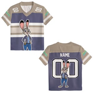 K&ouml;nnte beinhalten: Ein kurz&auml;rmeliges Trikot mit einem Zeichentrickfigurendesign. Die Vorderseite ist blau mit wei&szlig;en und beigen Streifen und dem Bild der Figur. Auf der R&uuml;ckseite befinden sich das Bild der Figur, die Nummer "00" und das Wort "NAME".