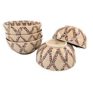 May include: A set of four cream-coloured ceramic bowls featuring a repeating lattice pattern of dark green stems and small red berries. Three bowls are stacked vertically, while one bowl is positioned in front, showing its exterior and base.