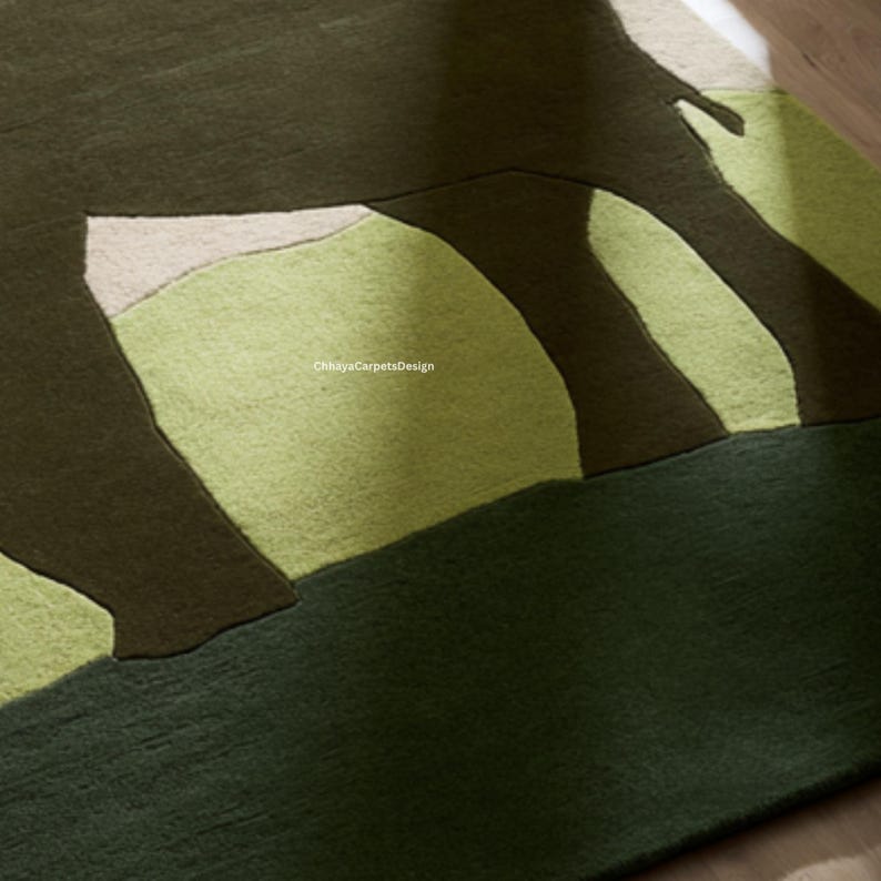 May include: A close-up of a green and brown area rug with a geometric design. The rug features a pattern of overlapping shapes in shades of green, brown, and beige. The rug is made of a soft, textured material.