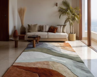 May include: A large, rectangular area rug with a layered, abstract design in shades of rust, beige, green, and gray. The rug is placed in a living room setting with a sofa, coffee table, and potted plant. The text "ChhayaCarpetsDesign" is visible on the rug.