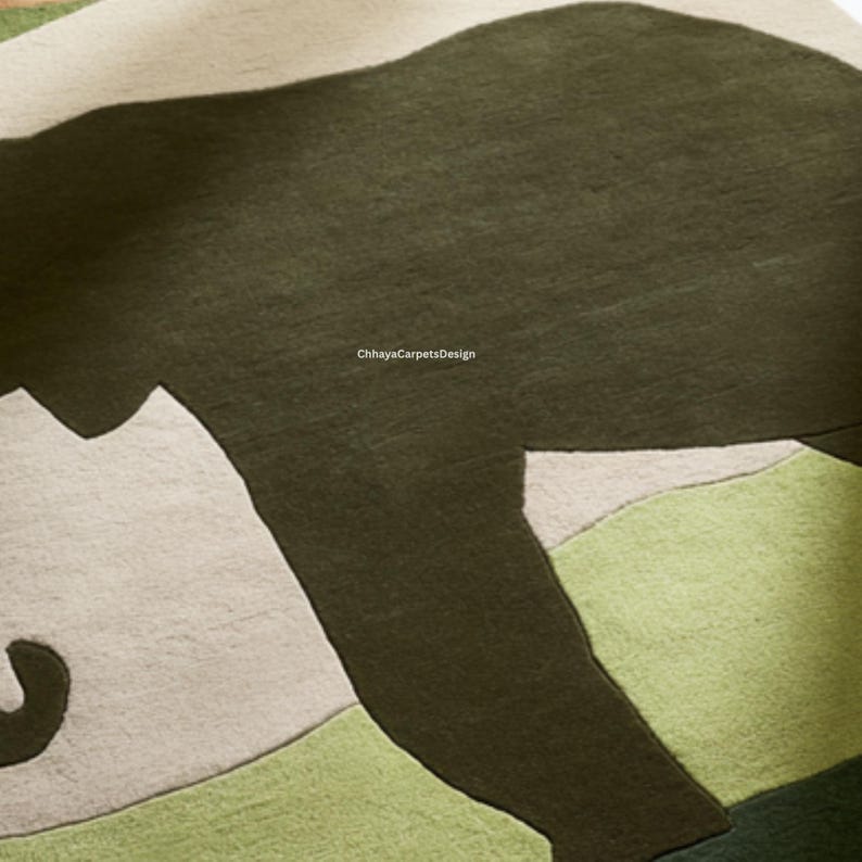 May include: A close-up of a rug with a bear design. The rug features a dark green bear shape against a backdrop of light green, white, and dark green. The text "ChhayaCarpetsDesign" is visible.