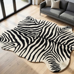 Peut inclure: Un grand tapis de forme irrégulière présentant un motif à rayures zébrées noir et blanc à fort contraste. Le tapis possède une surface douce et texturée, épousant la silhouette organique et asymétrique d'une peau d'animal sur le sol.