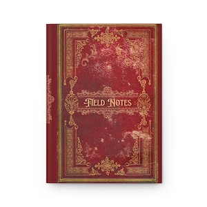 May include: A rectangular notebook with a deep red cover featuring a distressed texture and intricate gold filigree border patterns. The words FIELD NOTES are printed in a decorative gold serif font across the center of the front cover.