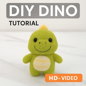 Könnte beinhalten: Ein handgefertigter grüner Filz-Dinosaurier mit gelbem Kamm und Bauchdetail. Der Dinosaurier hat schwarze Augen und einen lächelnden Mund. Der Text "DIY DINO TUTORIAL" steht oben und "HD-VIDEO" unten, was auf ein Bastelprojekt hindeutet.