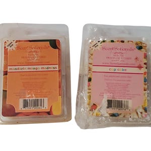 May include: Two ScentSationals fragrance cube packages. One is labeled "mandarin mango madness" with orange and green accents. The other is "cup cake" with colorful sprinkles. Both are in clear plastic packaging.