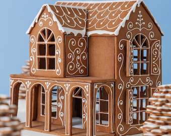 May include: A detailed gingerbread house with white icing accents. The house features multiple stories, arched windows, and a porch. The roof and edges are decorated with intricate icing patterns. The house is set against a light blue background.