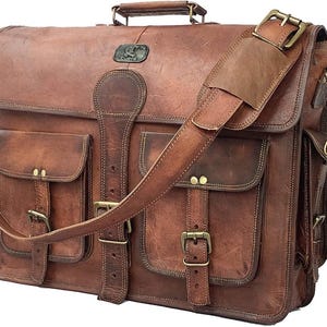 May include: A brown leather messenger bag with multiple pockets and a shoulder strap. The bag features brass buckles, a top handle, and a flap closure. The leather has a distressed appearance.