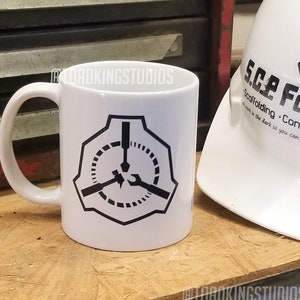 以下が含まれることがあります： 白いセラミック製のマグカップで、黒いロゴが描かれています。ロゴは、スタイリッシュな五角形の中に、ドライバー、レンチ、ハンマーが描かれています。マグカップは、木製の表面に置かれており、その隣には、黒いロゴが描かれた白い安全帽が置かれています。ロゴには、「SCP Foundation」と「Scaffolding - Construction」と書かれています。