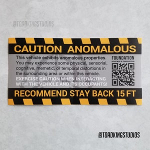 Może przedstawiać: Żółto-czarny znak ostrzegawczy z tekstem "CAUTION ANOMALOUS" i "RECOMMEND STAY BACK 15 FT". Znak zawiera również kod QR i tekst "FOUNDATION DEPARTMENT OF TRANSPORTATION".