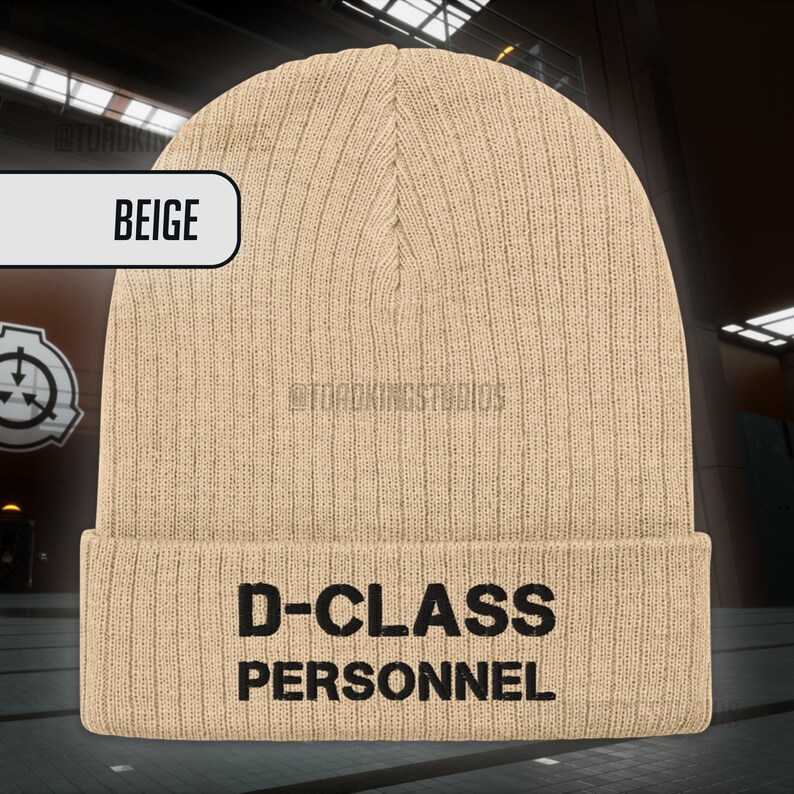May include: Beige knitted beanie with the text "D-CLASS PERSONNEL" in black.