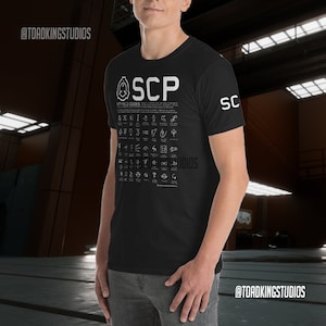 May include: Black t-shirt with a white graphic of the SCP Foundation logo and a list of "MTF Field Codes".