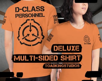 May include: Orange t-shirt with black text and a black and white symbol. The text on the shirt reads "D-Class Personnel" and "Deluxe Multi-Sided Shirt". The symbol is a circle with a downward pointing triangle inside. The shirt is a multi-sided shirt, meaning it has a different design on each side.