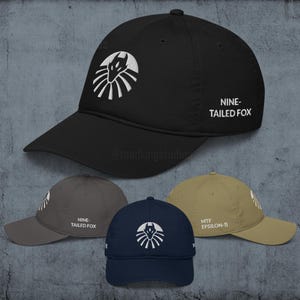May include: Black baseball cap with a white embroidered logo of a fox-like creature inside a circle. The text "NINE-TAILED FOX" is on the side. Additional caps in gray, navy, and tan are also shown.