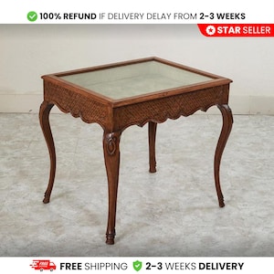 May include: A small, antique wooden table with a glass top. The table has ornate, carved details along the edges and on the legs. The legs are curved and elegant. The table is a warm brown color. The text in the image says "100% REFUND IF DELIVERY DELAY FROM 2-3 WEEKS".