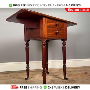 Op de afbeelding: Een antieke mahoniehouten bijzettafel met twee lades en een opklapbaar blad. De tafel heeft gedraaide poten met gesneden details en kleine zwenkwielen. De tekst "100% REFUND IF DELIVERY DELAY FROM 2-3 WEEKS" is zichtbaar.